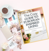 A mockup of the Cozy guide to European-inspired living sitting on a table with a coffee, cellphone, some flowers, notes, and jewelry scattered around it.